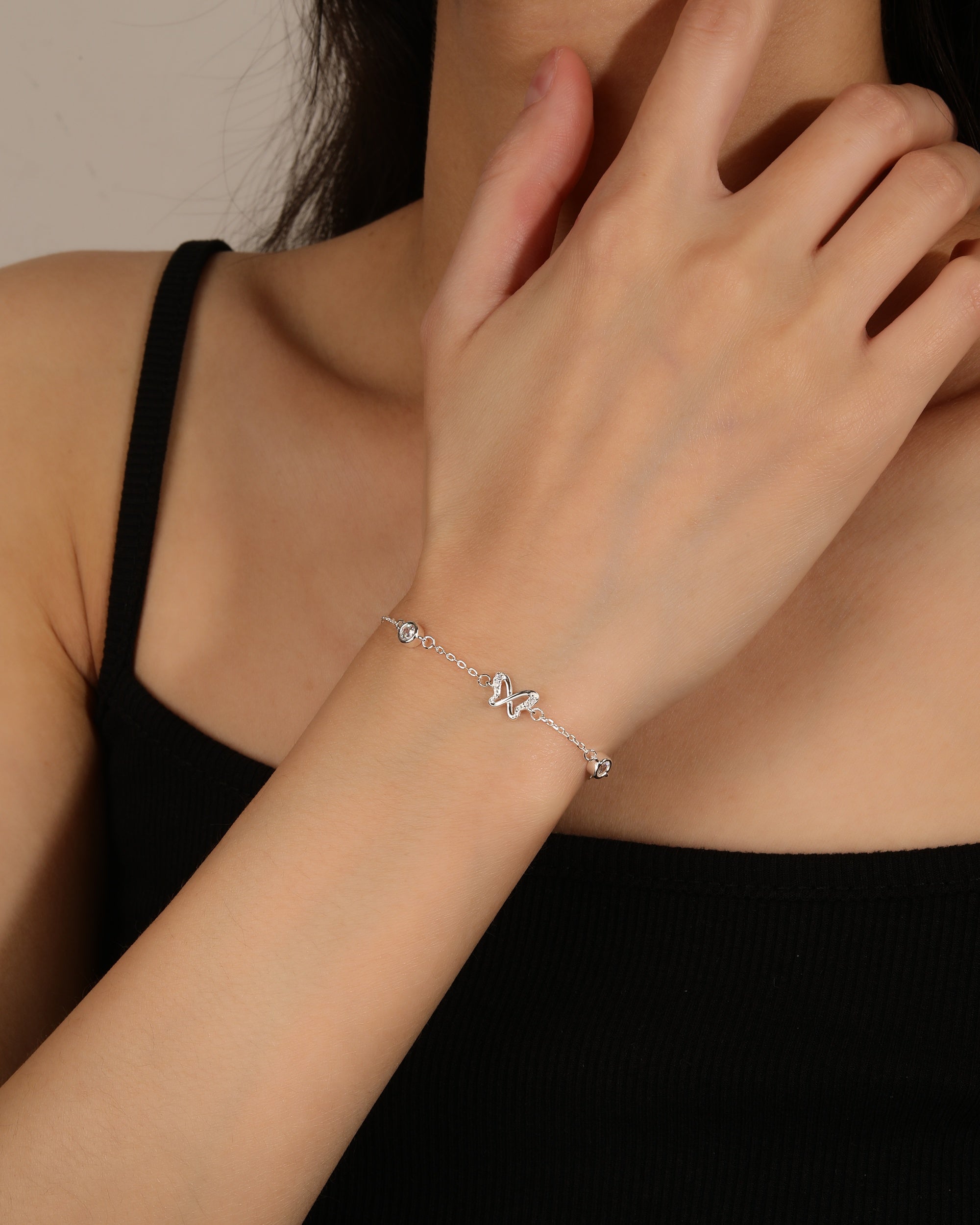 Pulsera sencilla de mariposa y circonias biceladas blancas en plateado