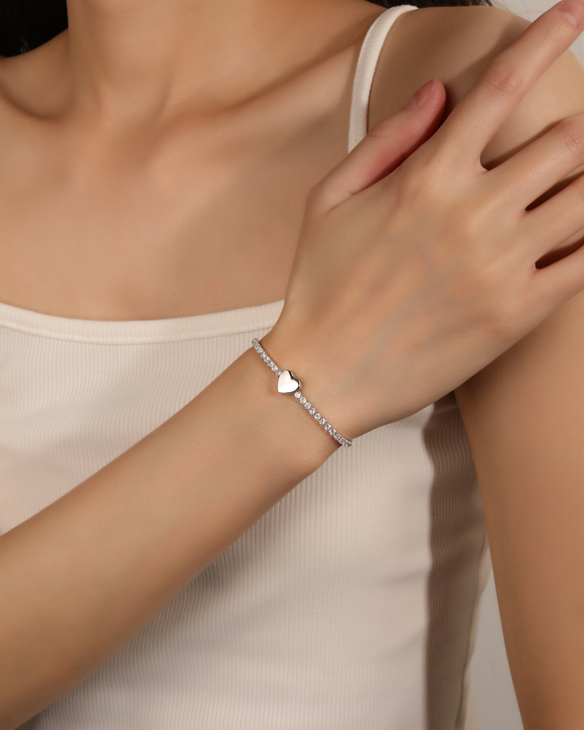 Pulsera de tenis con pasador de corazon liso y circonias blancas en rodizado