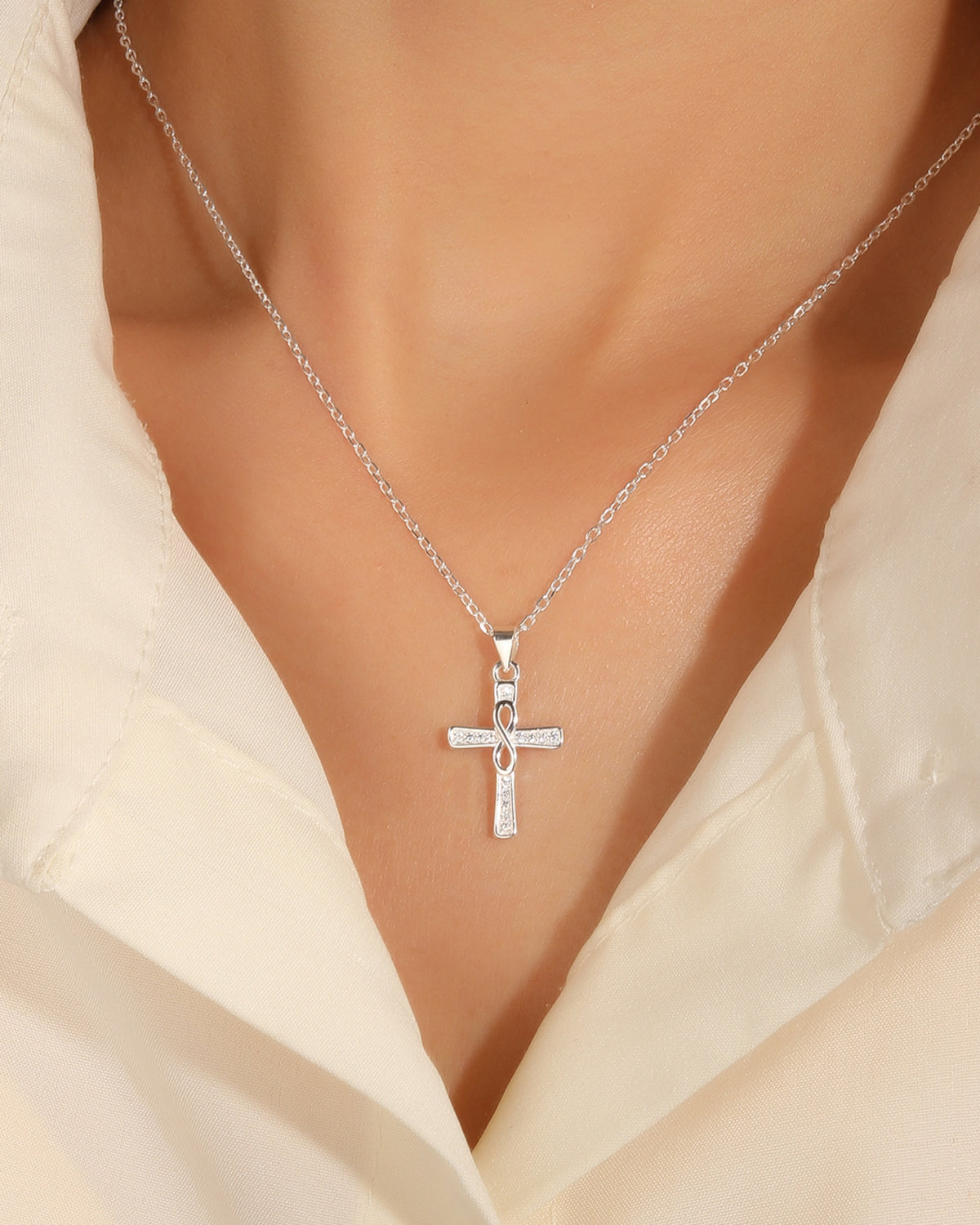 Collar de cruz con incrustación de circonias e infinito central 45+5cm en plateado