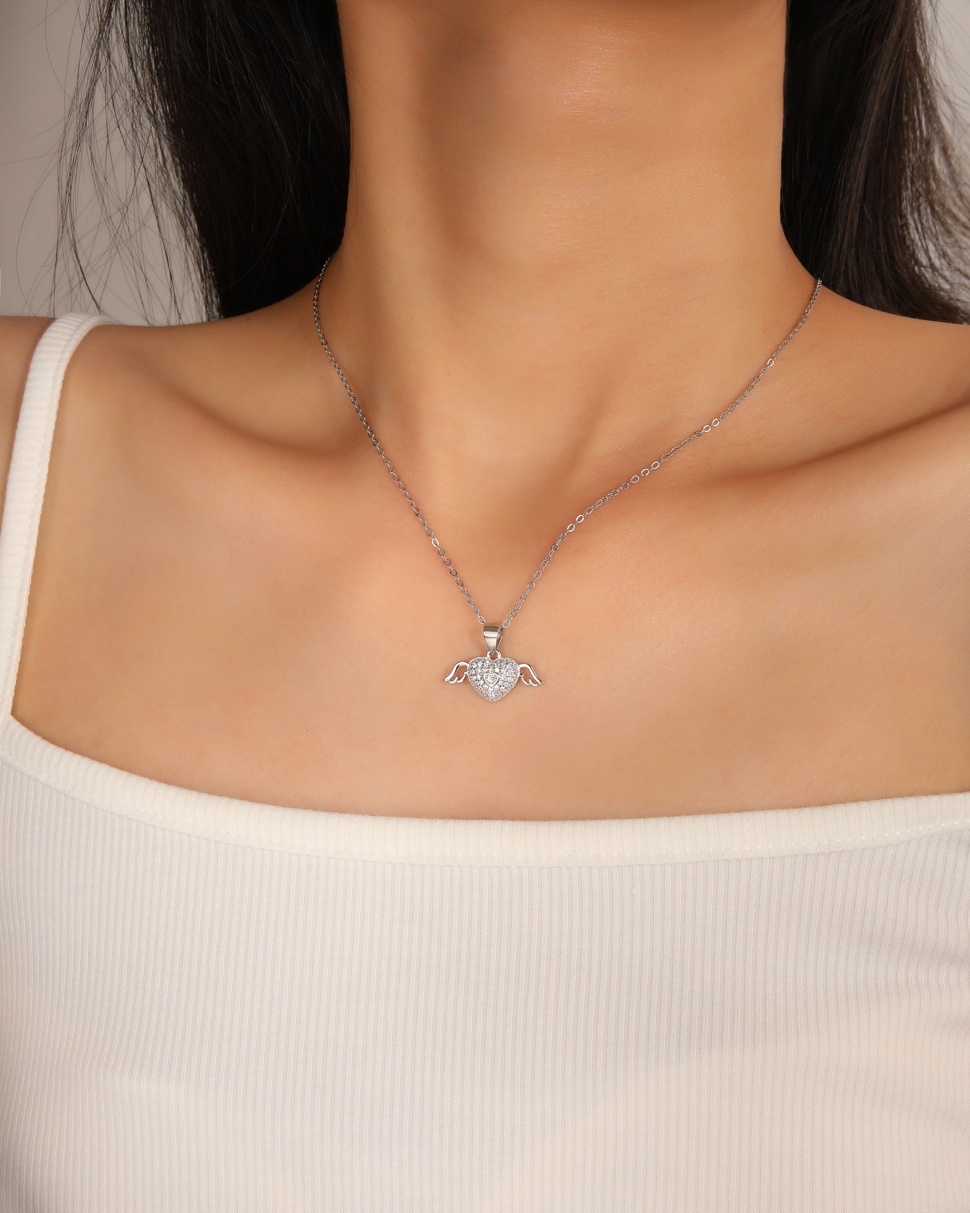 Dije de corazon con alas y circonias blanca en rodizado