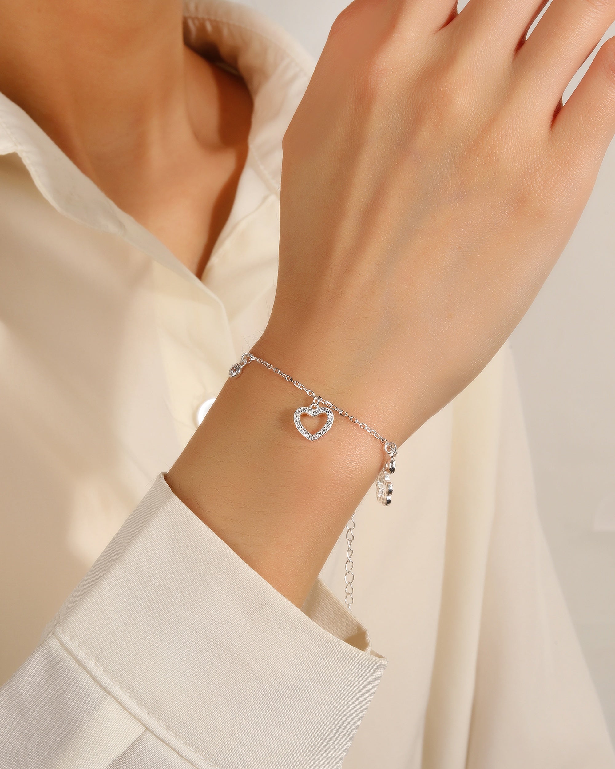 Pulsera con dijes varios con circonia blanca 17+3cm en plateado
